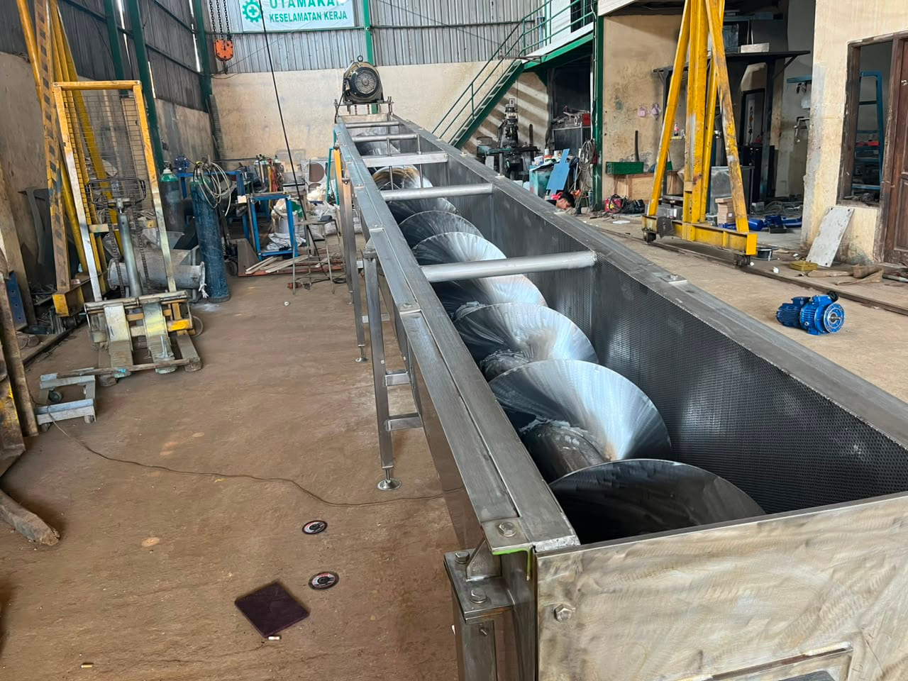 Screw feeder stainless steel berukuran panjang dalam proses perakitan di workshop