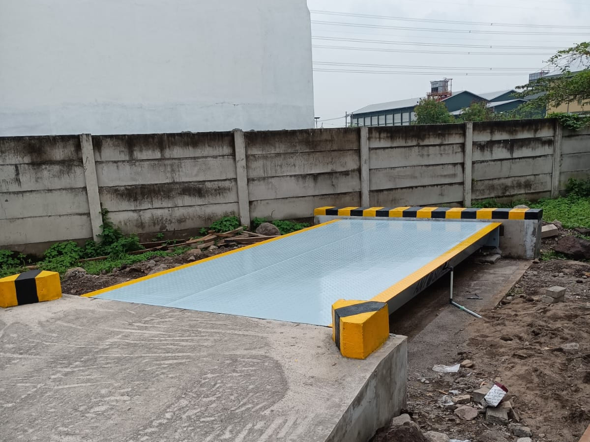 Jembatan timbang terpasang di atas landasan beton dengan pembatas bergaris kuning-hitam