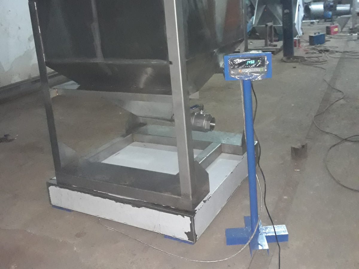 Hopper scale stainless steel bertumpu pada load cell, terhubung ke indikator penimbangan